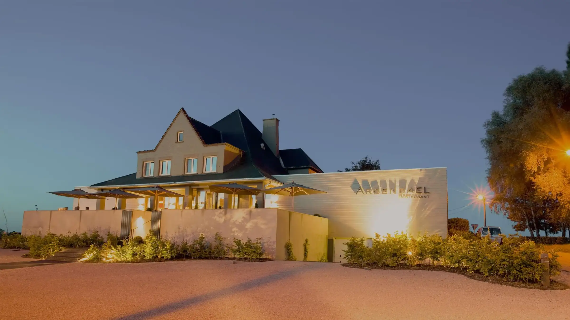 Restaurant Argendael bij valavond: het verlichte gebouw met de naam op de gevel